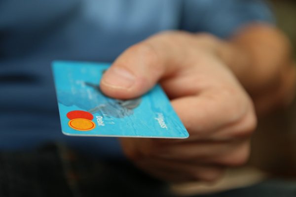 A man’s hand holding a credit card, paying for packing services
