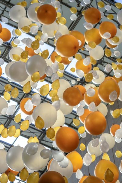 Many balloons – yellow, white, and golden