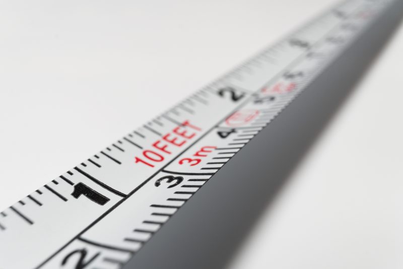 A white 10-foot steel measuring tape