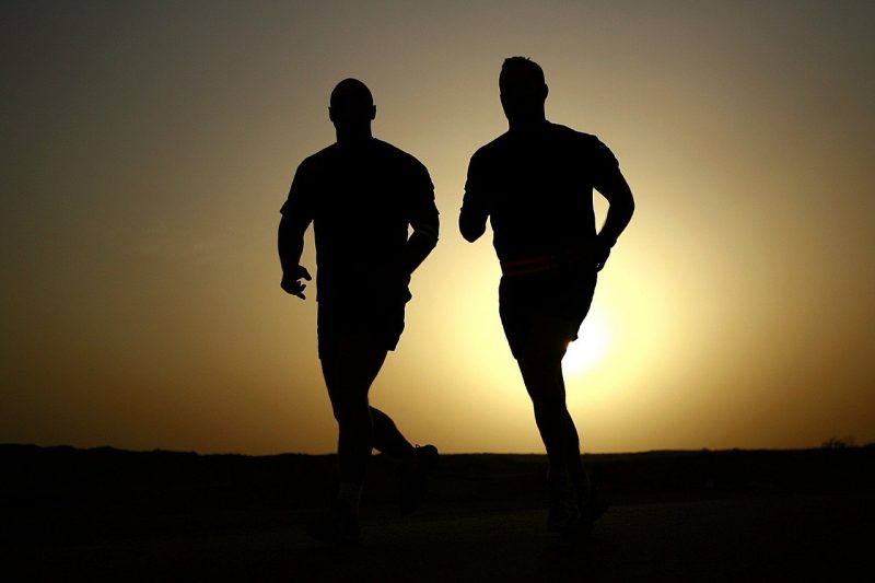 Two men running and discussing tricks for preventing injuries on moving day.